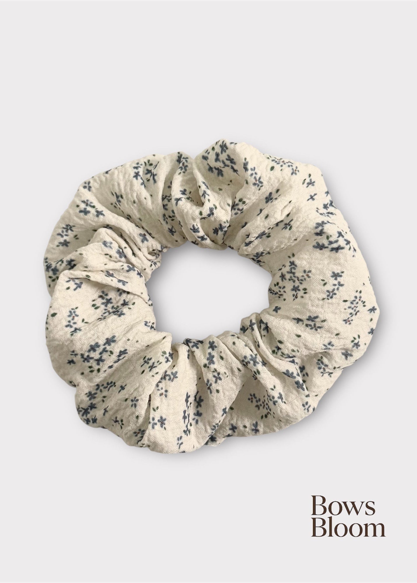 White scrunchie with tiny blue floral print, full product on light background